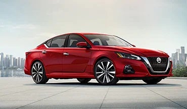 2023 Nissan Altima in red with city in background illustrating last year's 2022 model in Supreme Nissan in Slidell LA